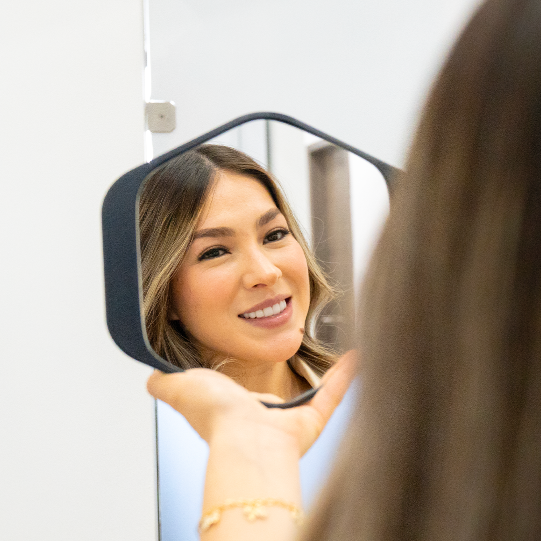 woman smiling at a mirror